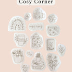 Cosy Corner design featuring embroidered illustrations of plants, mugs, and flowers in a charming layout.