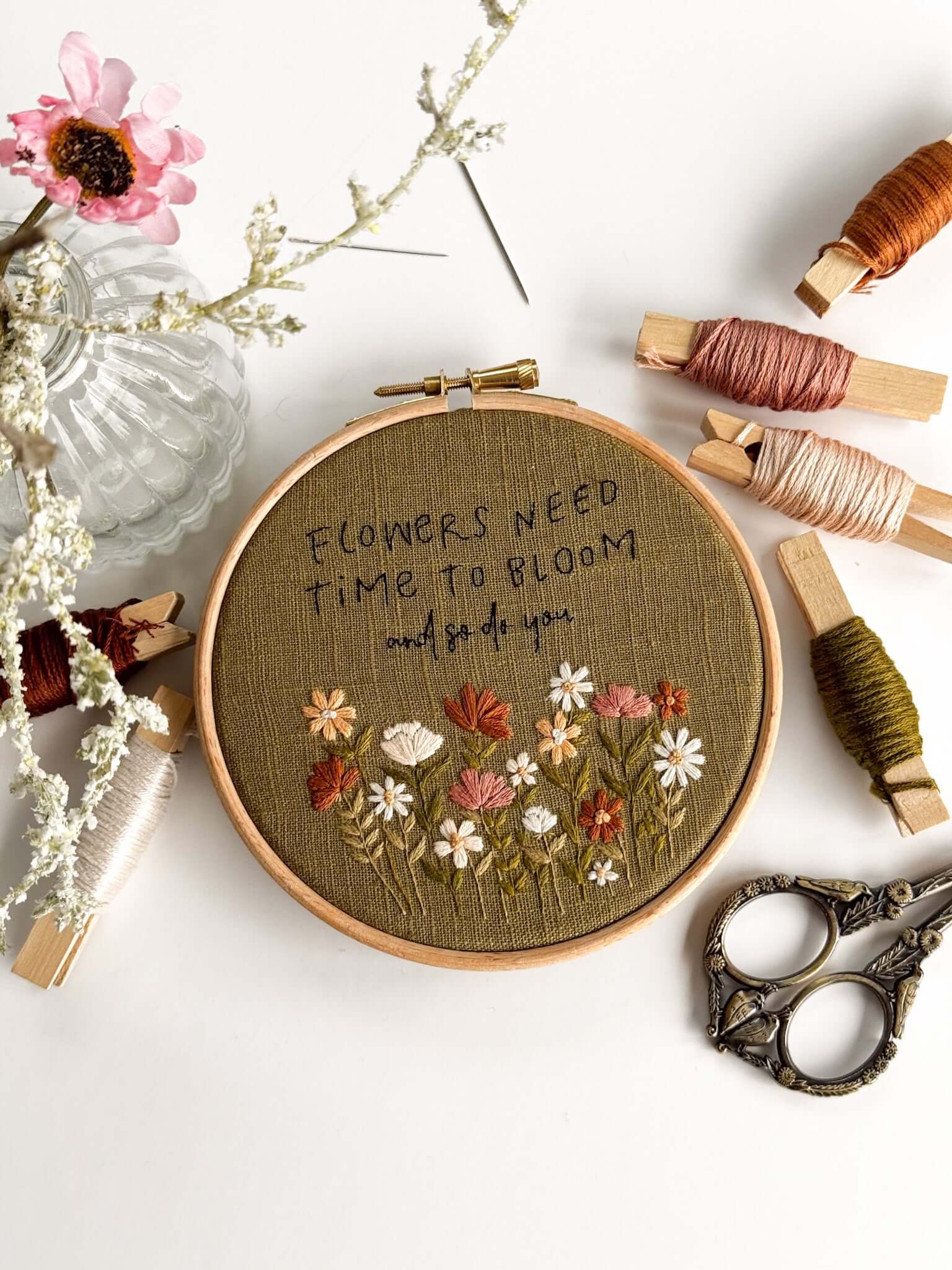 Beginner Embroidery Kit featuring floral design with text 'Flowers Need Time to Bloom' and embroidery supplies.