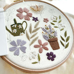 A butterfly magnetic needle minder on a floral embroidery piece