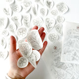 Outstretched hand holding a range of beautiful floral embroidery patterns