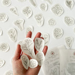 Outstretched hand holding a range of beautiful floral embroidery patterns