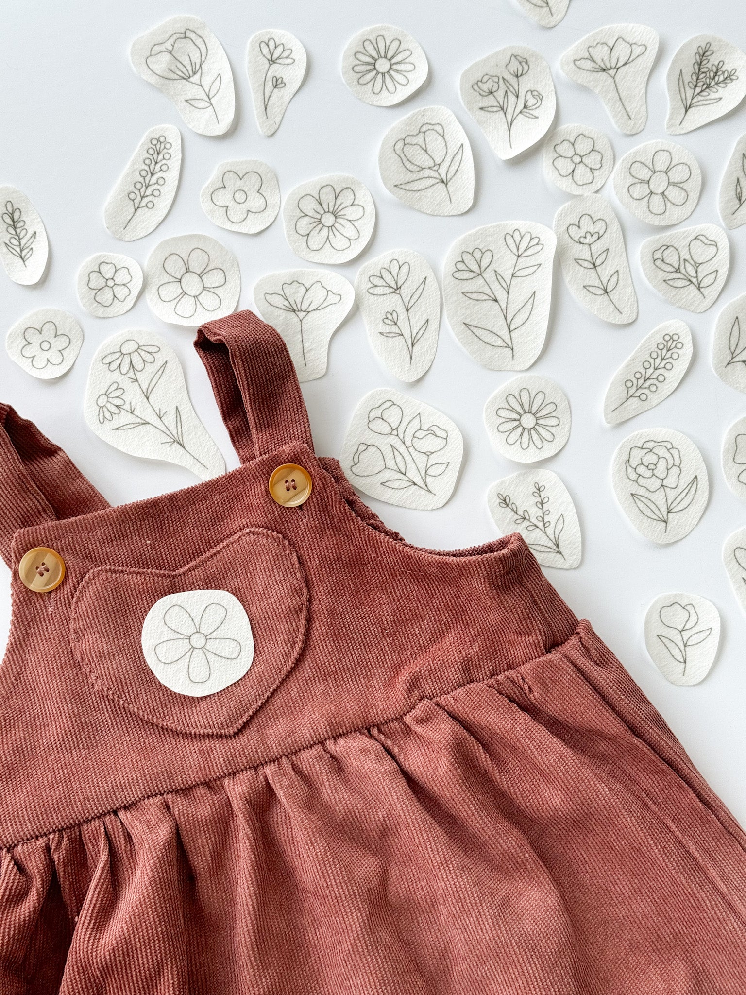  Floral embroidery designs with an example of how they can be embroidered onto baby clothes