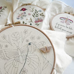 Embroidery hoops with floral and butterfly designs on a light background