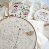 Embroidery hoops with floral and butterfly designs on a light background