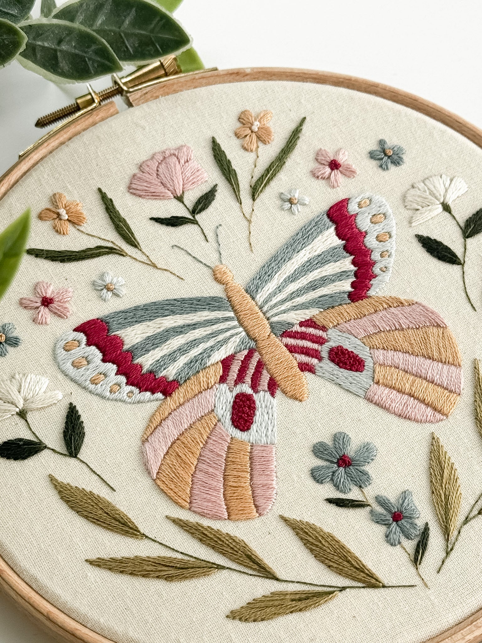 Embroidery hoop with a colorful butterfly and floral design.
