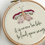 Embroidery hoop with butterfly design and motivational quote on a white background