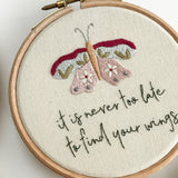 Embroidery hoop with butterfly design and motivational quote on a white background