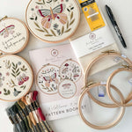 Butterfly embroidery kit featuring 3 patterns, hoops, needles thread, fabric, a pen and pattern booklet