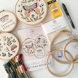 Butterfly embroidery kit featuring 3 patterns, hoops, needles thread, fabric, a pen and pattern booklet