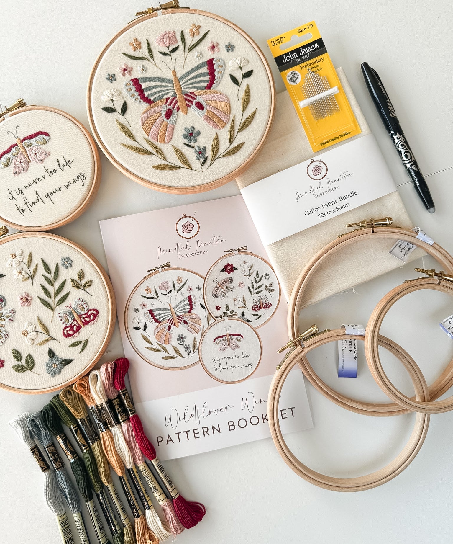 Butterfly embroidery kit featuring 3 patterns, hoops, needles thread, fabric, a pen and pattern booklet