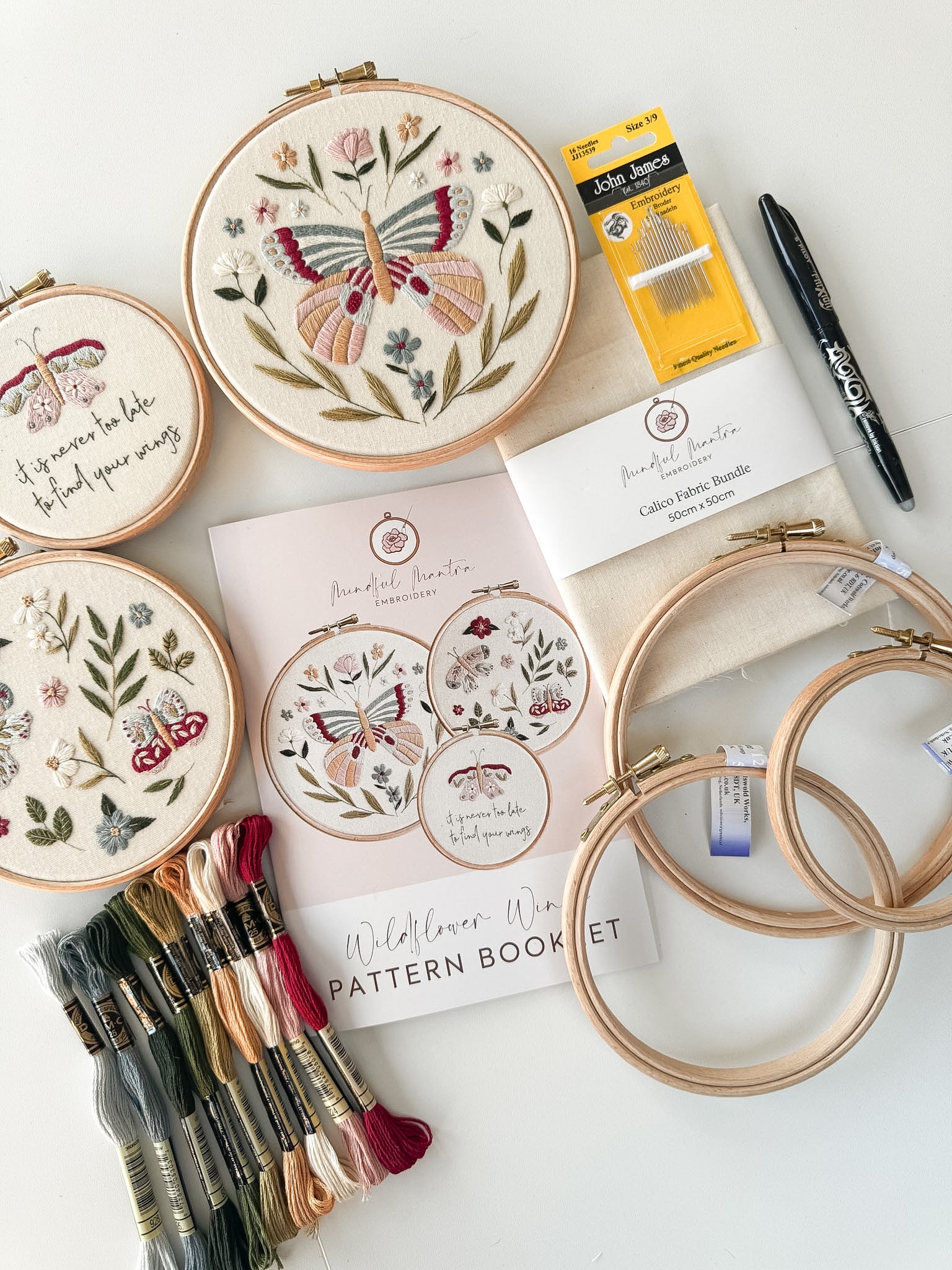Butterfly embroidery kit featuring 3 patterns, hoops, needles thread, fabric, a pen and pattern booklet