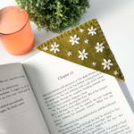 Beautiful felt bookmark with embroidered flowers on an open book, showcasing the bookmark embroidery kit in use.