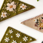 Hand-embroidered felt bookmarks from the bookmark embroidery kit, featuring floral designs and vibrant colors.