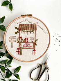 A Christmas embroidery pattern featuring a Holiday market stall