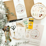 A beginner embroidery kit showing a patter booklet, thread, hoop, fabric and needles