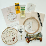 A beginner embroidery kit including a pattern booklet, thread, needles, hoop, calico fabric and Pilot FriXion Pen