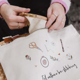 Person opening a white embroidery project bag