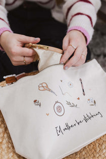 Person opening a white embroidery project bag