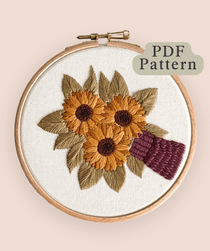 Sunflower Bouquet Embroidery Pattern displayed in an embroidery hoop with vibrant sunflower design.