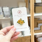 A hand holding a 1" x 1" Magnetic needle minder