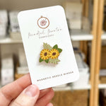 A closeup of a sunflower magnetic needle minder