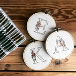 The letters 'E', 'A' and 'K' stitched using the initial embroidery kit