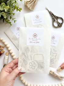 A hand holding a pack of Botanical Stick and Stitch embroidery patterns 