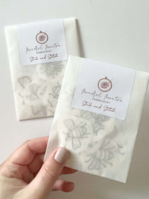 A hand holding a pack of stick and stitch embroidery patterns